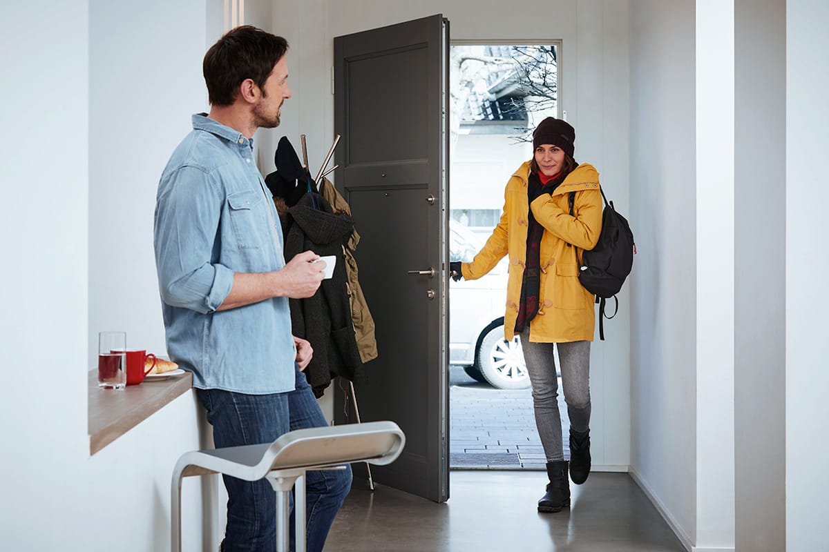 Pareja a la entrada de su casa en invierno